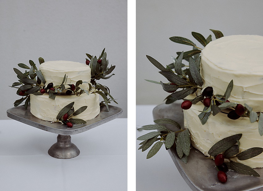 Zwei Bilder zeigen eine zweistöckige Torte mit weißem Zuckerguss auf einem Podest, perfekt für eine Hochzeitsfeier im Fischerstübchen Hemmingen. Mit grünen Blättern und dunkelroten Beeren geschmückt, verströmt sie einen rustikalen Charme. Der neutrale Hintergrund betont die elegante Schlichtheit der Torte.