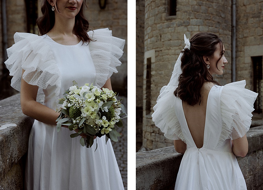 Eine Frau in einem weißen Kleid mit Rüschenärmeln und offenem Rücken steht vor dem historischen Schloss Marienburg. Sie hält einen Strauß weißer und grüner Blumen in der Hand, ihr Haar ist mit einem weißen Accessoire geschmückt. Das Bild, perfekt für ein Hochzeitsshooting, ist in zwei Ansichten aufgeteilt: Vorder- und Rückseite.