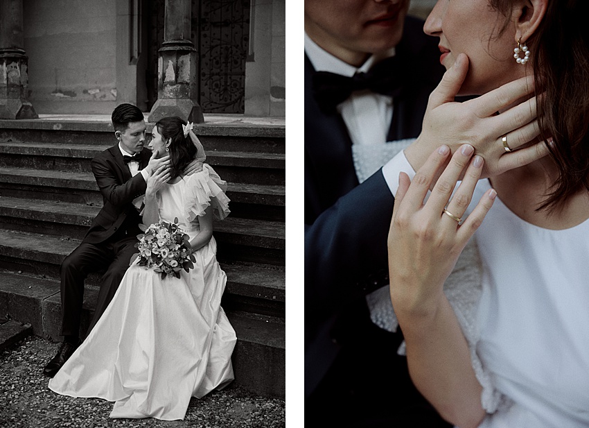 Ein Paar sitzt auf Steinstufen; der Mann richtet das Haar der Frau, die einen Blumenstrauß hält und ein Brautkleid trägt. Sie beugen sich eng aneinander und wirken zärtlich. Aufgenommen während ihres Hochzeitsshootings am historischen Ort von Schloss Marienburg, streichelt ihre Hand sein Gesicht und präsentiert einen atemberaubenden Ring.